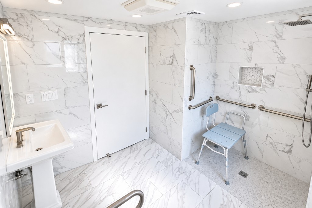 Walk-in shower with grab bars and shower chair